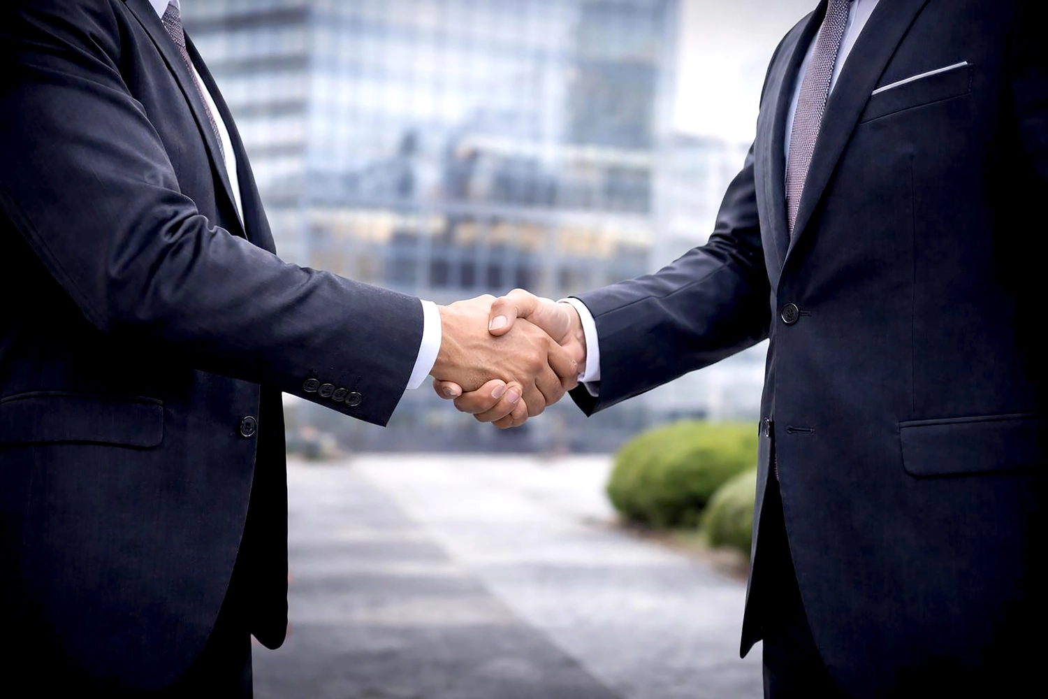 Mes West GmbH - Fachkräfte-, Investitions- und Unternehmenslösungen - Zwei Männer in Anzügen schütteln sich die Hände