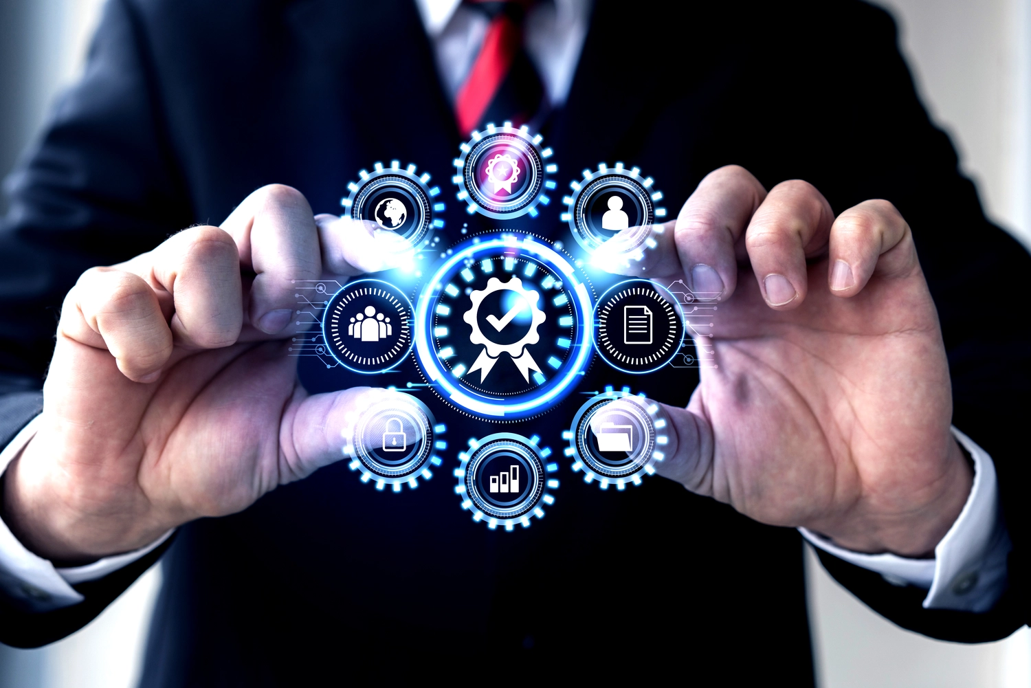 Mes West GmbH - Fachkräfte-, Investitions- und Unternehmenslösungen - Eine Person im Anzug hält eine digitale Benutzeroberfläche mit leuchtenden, miteinander verbundenen Zahnrädern und Geschäftssymbolen.